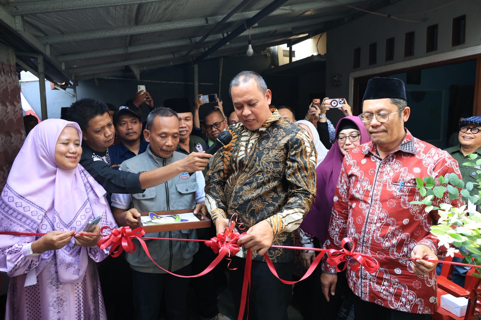 Wali Kota Bekasi Tri Adhianto meresmikan bantuan Program Rutilahu di Pondok Gede bersama penerima manfaat.